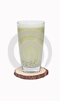 Soy products milk in tall glass on small wooden cutting board drinking.