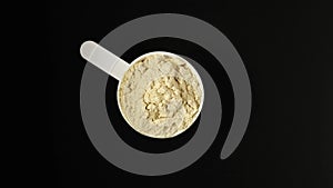 Soy protein concentrate, isolated from soybean in plastic measuring spoon, top view. Pure Whey Protein