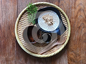 Soy pudding in the black cup topped with  brown sugar and sugar syrup and hot tea on bamboo tray
