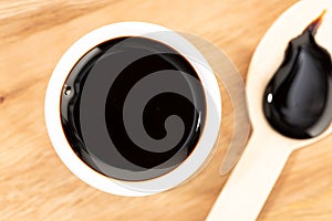 Soy sauce in bowl on wooden table