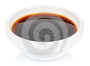 Soy sauce in a small white ceramic round bowl isolated on white background