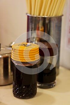 Soy sauce, vinegar, chilli oil, sugar and chopsticks on a table of a hong kong style traditional canteen