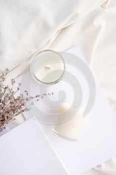 Soy wax aroma candles in jar on bed with lavender flowers. Candle mockup design