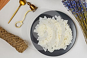 Soy wax, wick, cap, lavender - ingredient for handmade candles on black plate and white background. Flat lay. Top view. Ð¡andle