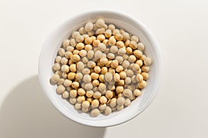 Soybean legume. Top view of grains in a bowl. White background