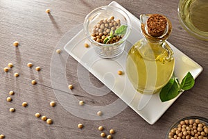 Soybean oil and dry soy beans on plate elevated view