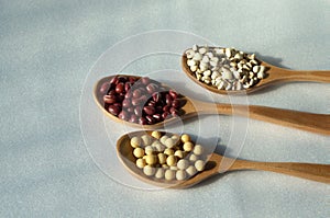 Soybeans, adzuki beans and Job\'s tears in wooden spoons, organic food collection