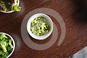 Soybeans in a small white bowl on a wooden table