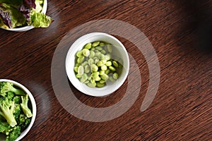 Soybeans in a small white bowl on a wooden table