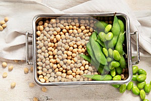 Soybeans on light cotton and wooden background. Vegan food concept