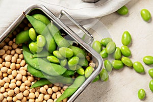 Soybeans on light cotton and wooden background. Vegan food concept