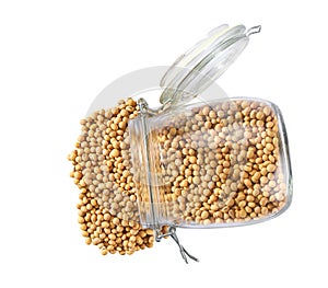 soybeans spill out of a glass storage jar isolated on white background top view