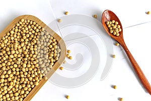 Soybeans in wooden box, closeup of organic soya beans on white background