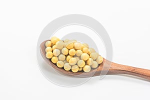 Soybeans in a wooden spoon isolated on white background