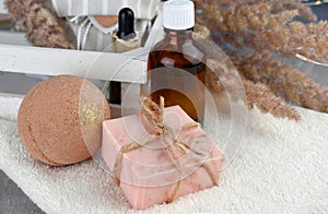 Spa aroma set with bath bombs, essential oil bottle and soap bar on towel. Natural homemade cosmetic.