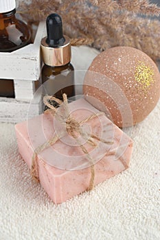 Spa aroma set with soap bar  bath bombs and essential oil bottle on towel.