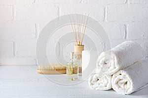 SPA aromatherapy background. Still life with white towel, bath oil, massage brush