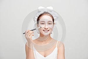 Spa Asian woman applying facial clay mask. Spa beauty concept