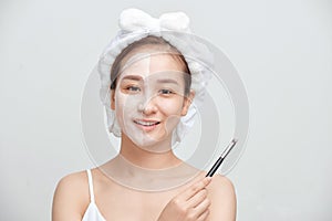 Spa Asian woman applying facial clay mask. Spa beauty concept