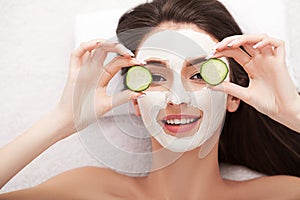 Spa. Attractive funny woman with a clay mask on her face.