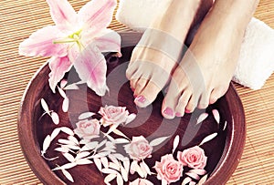 Spa background with beautiful feet, flowers and petals