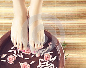 Spa background of beautiful feet and petals