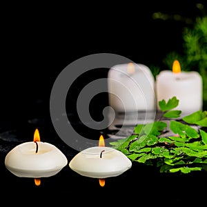 spa background of green branch Asparagus, fern and candles on zen basalt stones with drops in reflection water