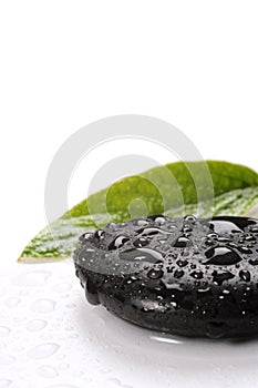 Spa basalt stones and green leaves with water drops