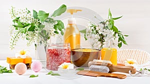 Spa and bath accessories with bath salts and beauty treatment products on white table. Wellness concept