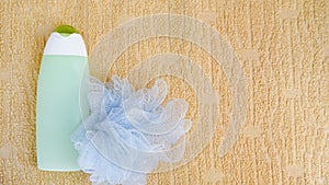 Spa bath concept. Flat lay background washcloth and shampoo on towel. Green bottle. Top view copy space