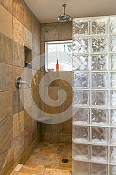 Spa bathroom shower area with stone tile and glass block walls in contemporary upscale home interior