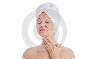 Spa and beauty concept. Aged good looking woman with white towel on her head. UK