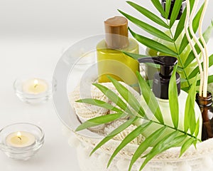 Spa beauty products and candles with palm leaves