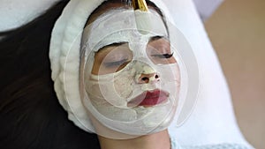 Spa beauty treatment, skincare. Woman getting facial care by beautician at spa salon. Young cosmetologist applying