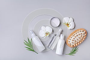 Spa, beauty treatment and wellness background with massage brush, orchid flowers and cosmetic products. Top view and flat lay