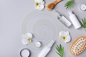 Spa, beauty treatment and wellness background with massage brush, orchid flowers and cosmetic products. Top view and flat lay