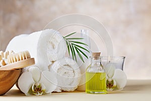 Spa, beauty treatment and wellness background with massage oil, orchid flowers, towels, cosmetic products and burning candles