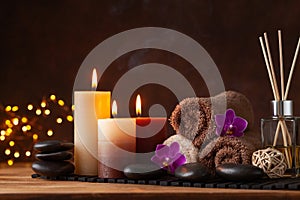 Spa, beauty treatment and wellness background with massage stone, orchid flowers, towels and burning candles