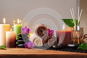 Spa, beauty treatment and wellness background with massage stone, orchid flowers, towels and burning candles
