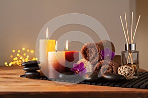 Spa, beauty treatment and wellness background with massage stone, orchid flowers, towels and burning candles