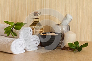 Spa, beauty and wellness background: towel, cosmetic massage oil, fresh leaf, sea salt with shells and candle