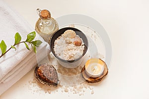 Spa, beauty and wellness background. Towel, cosmetic massage oil, leaf, sea salt with shells and candle