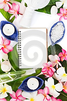 Spa botanical tropical concept herb salt coconut oil and plumeria flowers on tropic leaf background flat lay top view