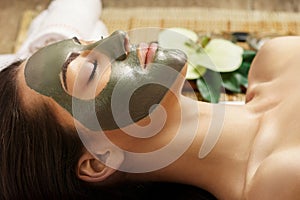 Spa Clay Mask. Woman with clay facial mask   in beauty spa. Skin