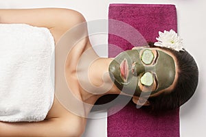 Spa Clay Mask. Woman with clay facial mask and cucumbers on eyes