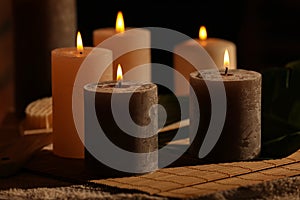 Spa composition with burning candles on massage table in wellness canter, closeup