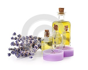 Spa composition with candles, essential oil and beautiful lavender on white background