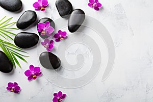 Spa composition with flowers, green leaves and massage stone on white background top view. Beauty treatment and relaxation concept