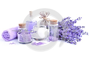 Spa composition with flowers of lavender, cream, salt and bottle of essential oil on a white background