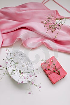 Spa composition with pink soap bar with ceramic soap dish, silk babric and flowers